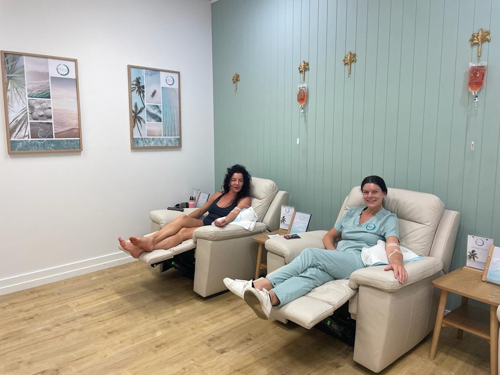 Two women receiving IV vitamin therapy in recliner chairs at Infuze Me Cannonvale