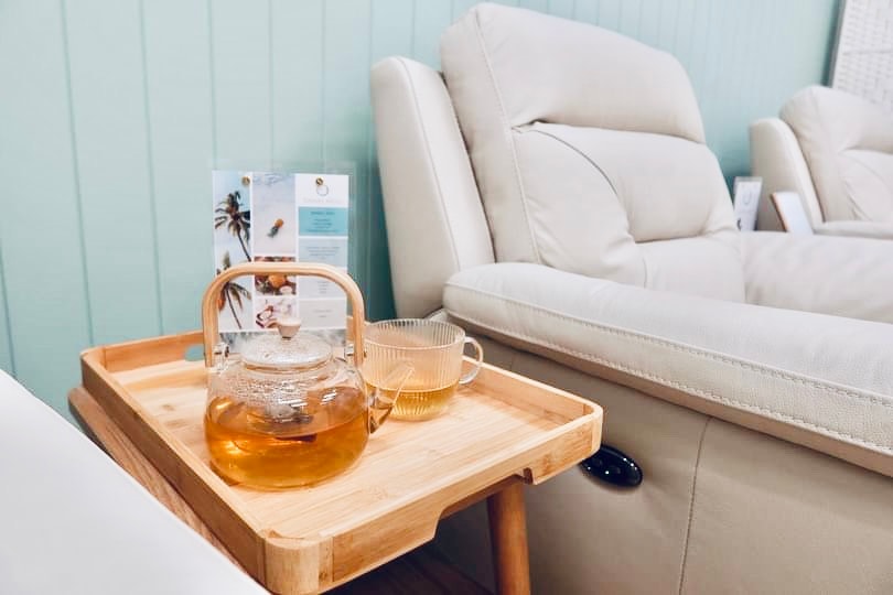 Herbal tea service on bamboo tray inside the Infuze Me clinic — relaxation between treatments